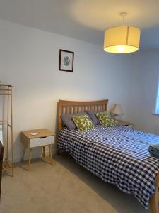 a bedroom with a bed and a table and a lamp at Torias Place - Lenham in Maidstone