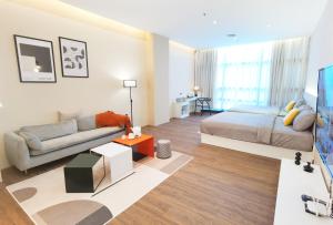 uma sala de estar com uma cama e um sofá em The Sandstone - Bangsar Trade Centre em Kuala Lumpur