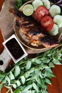 a plate of food with fish and vegetables on a table at The Hawk's Nest Resort in Sabong