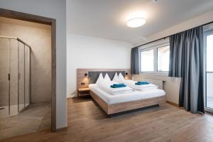 a bedroom with two beds and a large window at T-Lodge Zauchensee in Altenmarkt im Pongau