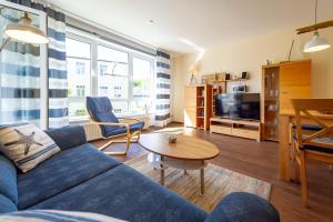 ein Wohnzimmer mit einem blauen Sofa und einem Tisch in der Unterkunft Haus Holstein - WG 6 mit Balkon, strandnah in Ostseebad Sellin