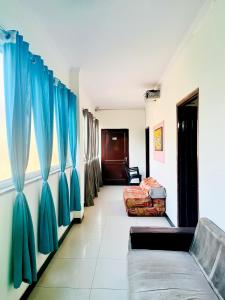 新德里的住宿－Hotel Retreat Near AIIMS Hospital，走廊上设有蓝色窗帘和沙发