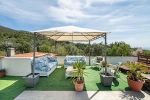 a patio with chairs and an umbrella on a roof at Beach Room Apartment in Quartu SantʼElena +15 photos