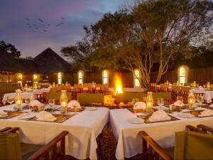 a group of tables with white table linens and lights at Kubu Safari Lodge in Hoedspruit