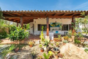 Un patio trasero con pérgola y un jardín con plantas. en Jungle Room Apartment, en Quartu SantʼElena