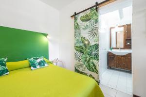 Un dormitorio con una cama amarilla y un lavabo. en Jungle Room Apartment, en Quartu SantʼElena