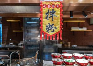 Crowne Plaza Nanchang Riverside, an IHG Hotel في نانتشانغ: وجود علامة معلقة على منضدة في المطبخ