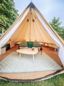 a tent with two chairs and a table at Strandbad Steckborn mit Herberge, Camping & Glamping in Steckborn