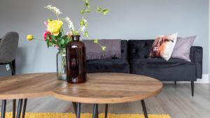 a living room with a vase on a coffee table at Blairmuire House in Broxburn