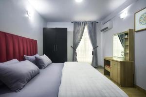 - une chambre avec un grand lit blanc et une fenêtre dans l'établissement Crib 6, à Lagos