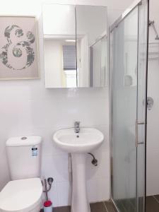 Un baño blanco con inodoro y lavabo. en Serene Double Studio - Mins to Station & UNSW, en Sídney