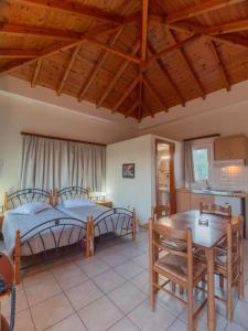 ein Schlafzimmer mit einem Bett und einem Tisch sowie eine Küche in der Unterkunft Apartments Hotel & Studios, Xifoupolis in Monemvasia