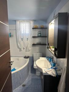 La salle de bains est pourvue d'un lavabo, d'une baignoire et de toilettes. dans l'établissement Eva’s House, à Vári