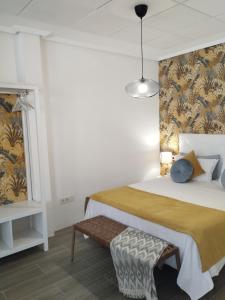 Loft Apartamento Sevilla 16 في أليكانتي: غرفة نوم بسرير كبير ومقعد
