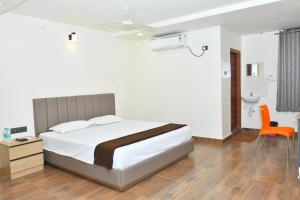 a bedroom with a bed and a desk and a chair at SWAGATH RESIDENCY in Devarkonda