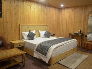 达纳尔蒂The Grand View Resort的一间带床的卧室，位于一间带木墙的房间里