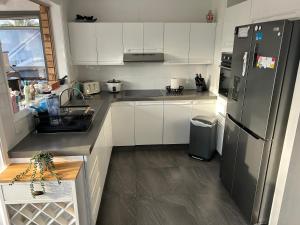 a kitchen with white cabinets and a stainless steel refrigerator at Waters Edge Golden Sunrise Two Bedroom Apartment Recent Reno in Rocky Point +26 photos