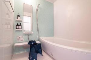 a bathroom with a white tub and a toilet and a sink at 新屋 札幌市中心薄野車程5分 廁所x2 浴室x1 可停車2台 高速Wi-Fi 對街超商 in Sapporo +19 photos