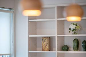 a white book shelf in a room with flowers at 新屋 札幌市中心薄野車程5分 廁所x2 浴室x1 可停車2台 高速Wi-Fi 對街超商 in Sapporo