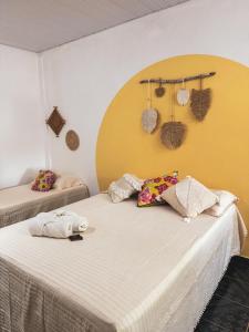 Duas camas num quarto com uma parede amarela em Carimbó Pousada e Hostel em Alter do Chão