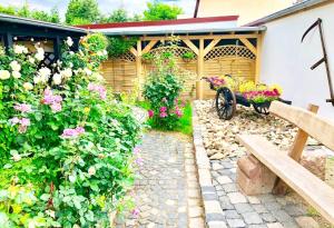 un jardín con un banco y un ramo de flores en Ferienwohnungen Grimma 4, en Grimma