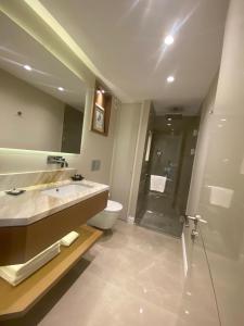 La salle de bains est pourvue d'un lavabo, de toilettes et d'une douche. dans l'établissement Cheya Deluxe Residence Nisantasi Istanbul City Center, à Istanbul