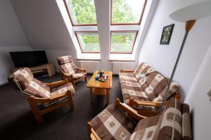 a living room with chairs and a table and a tv at IT Centrum Apartments in Vrchlabí
