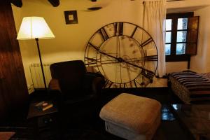 uma sala de estar com um grande relógio na parede em CAN LLOBET Espai Rural Slow em Fogars de Montclus