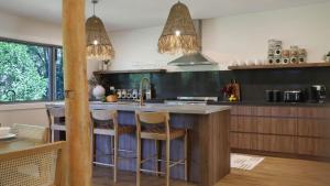 a kitchen with a island with bar stools at Saltwater Creek in Bundannon +22 photos