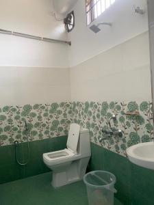 een badkamer met een toilet en een wastafel bij JP Hotel in Tezpur