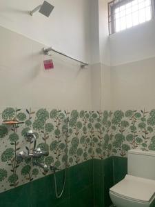 ein Bad mit einer Dusche und einem WC in der Unterkunft JP Hotel in Tezpur