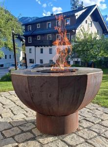 une fontaine de feu dans une cour avec un bâtiment en arrière-plan dans l'établissement Hotel-Pension Hoferhaus, à Neukirchen am Großvenediger