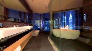 ein Badezimmer mit zwei Waschbecken und einer Badewanne mit Blick auf die Stadt in der Unterkunft Imperial KLCC Residence in Kuala Lumpur