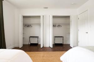 een slaapkamer met witte muren en 2 kasten bij Phillips BunkHouse by the Sea in Fort Lauderdale