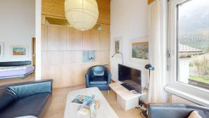 Una sala de estar con un sofá y un televisor. en Feriensiedlung Trü 7, en Scuol