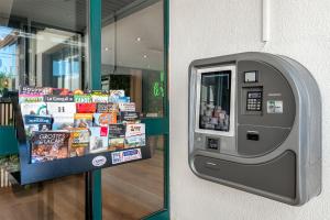 uma máquina de auto-pagamento em frente a uma loja em Le Roxane em Bergerac