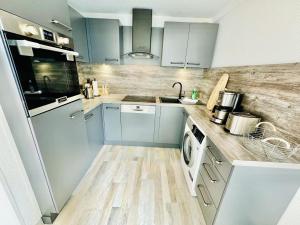 a kitchen with blue cabinets and a washer and dryer at Ferienhaus Matrose in Warnemünde