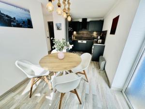 a dining room with a wooden table and white chairs at Ferienhaus Matrose in Warnemünde