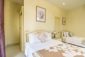 um quarto com duas camas brancas num quarto em The Sunshine Hoi An Villa em Hoi An