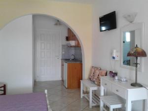 a living room with a couch and a table and a door at Elpidas studios in Agia Anna Naxos