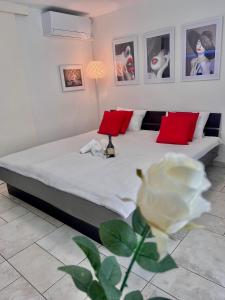 a bedroom with a bed with red pillows and a white flower at Anabella Apartment in Izola
