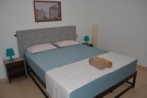 Nakis Apartment Stavros في ستافروس: غرفة نوم بسرير ازرق وعليها منشفة