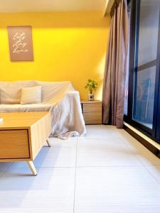 a yellow room with a couch and a table at Anping Nordic sea view three bedrooms in Anping