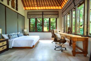 une chambre avec un lit et un bureau avec un ordinateur dans l'établissement The Ubāri Bali - Luxury Riverside Escape, à Ubud 72 autres photos