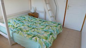 1 dormitorio con cama con colcha en Appartement à 50 mètres de la plage, en Saint-Jean-de-Monts