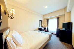 um quarto de hotel com uma cama e uma televisão em Nara Royal Hotel em Nara