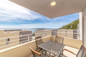 a balcony with a table and chairs and a view at Luxury Apartment Maglica in Makarska