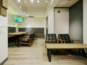 a conference room with wooden tables and leather chairs at Akasaka Guesthouse HIVE in Tokyo
