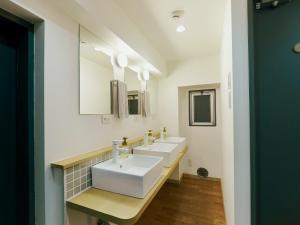 a bathroom with two sinks and two mirrors at Akasaka Guesthouse HIVE in Tokyo