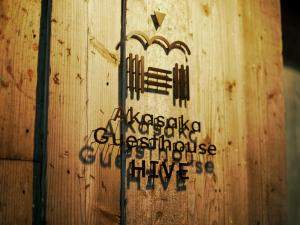 eine Holzwand mit Kreuz und Schrift darauf in der Unterkunft Akasaka Guesthouse HIVE in Tokio